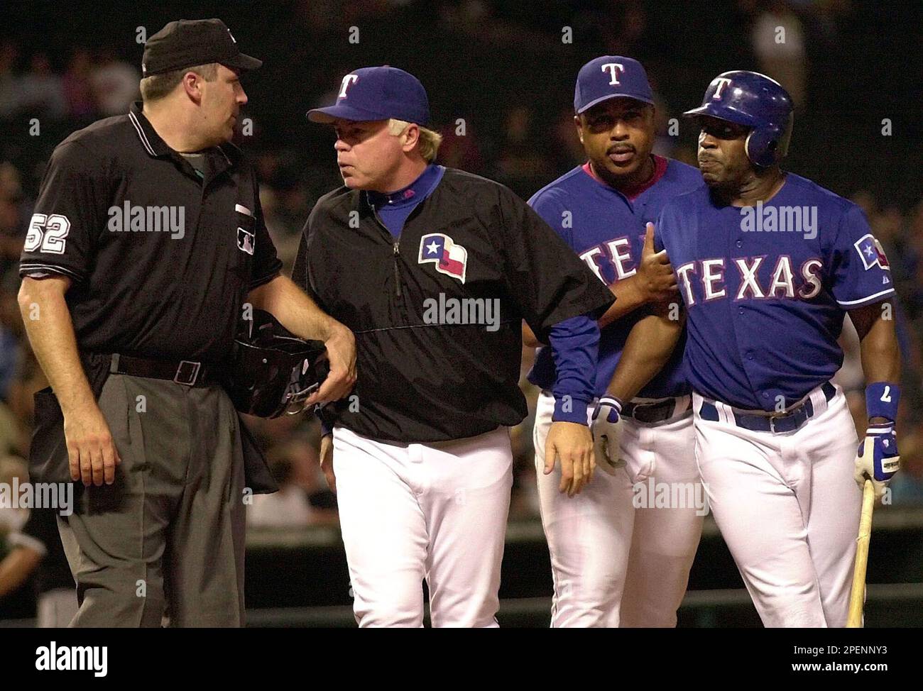 Texas Rangers' Eric Young, right, is held back by third base coach DeMarlo  Hale as manager Buck Showalter, second from left, argues a strikeout call  with home plate umpire Bill Welke (52)