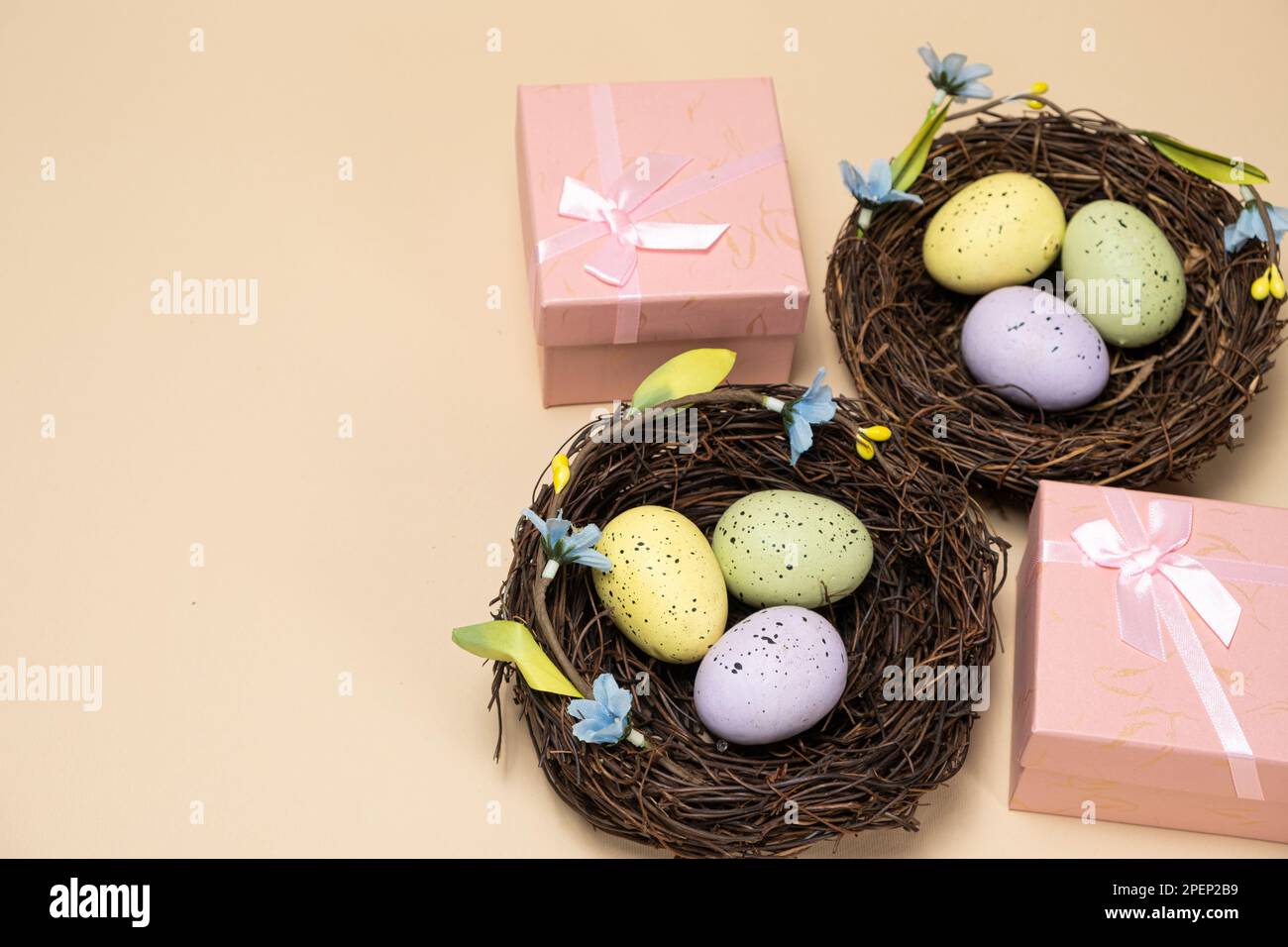 Gifts for Easter, Easter sale. Eggs in nests and gift boxes on a beige background. Stock Photo