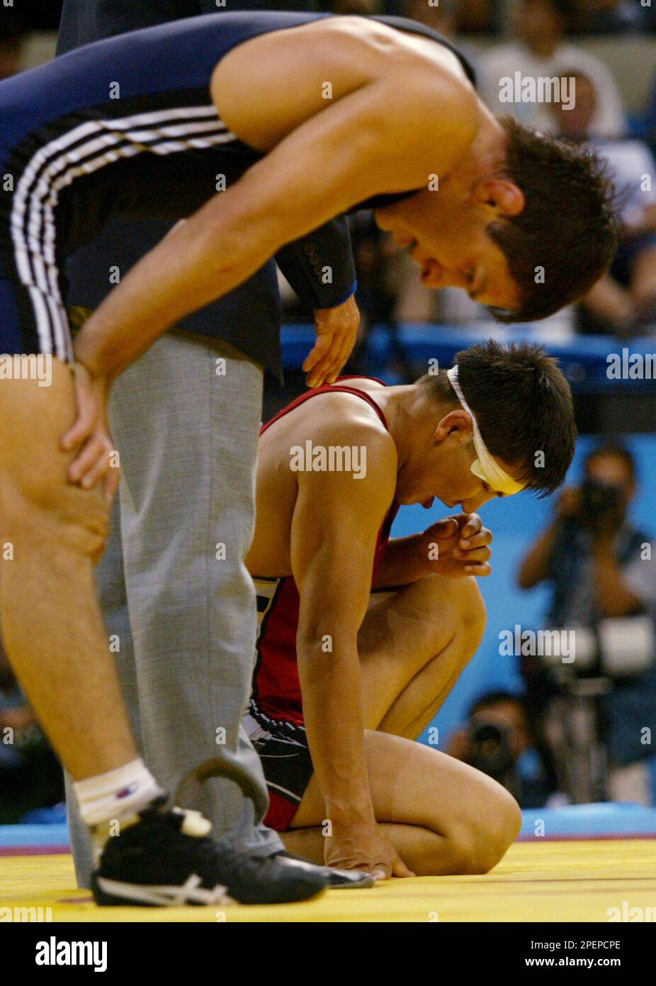 Leonid Spiridonov, of Kazakhstan, background, looks down after being ...