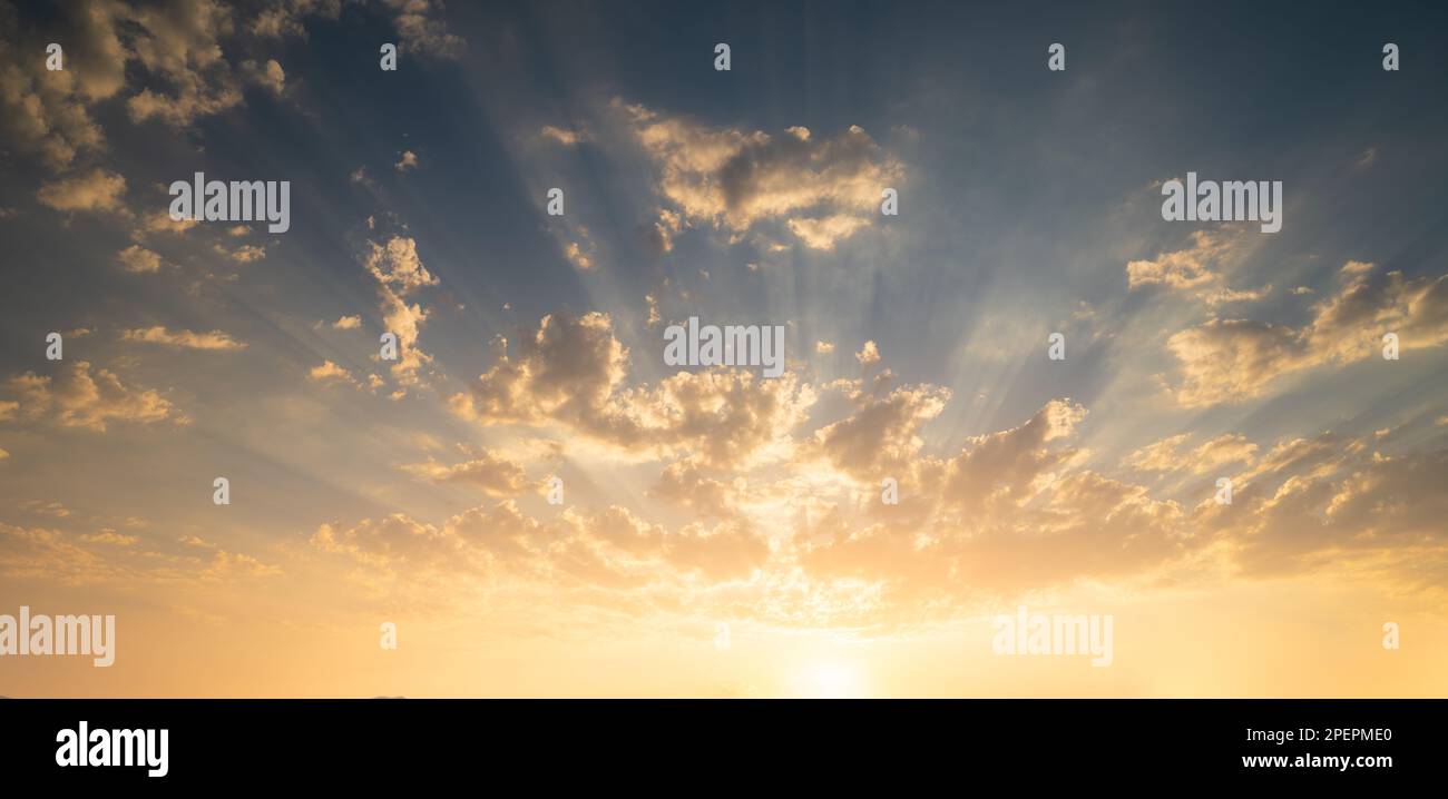 Sunrise or Sunset background. Sun fringes emerge from the clouds. Dramatic sky scene. Stock Photo