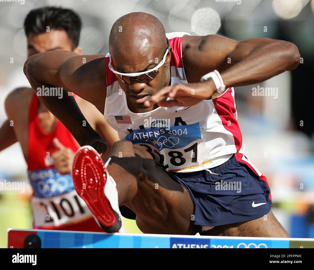 Allen Johnson, of the United States clears a hurdle in a qualifying ...
