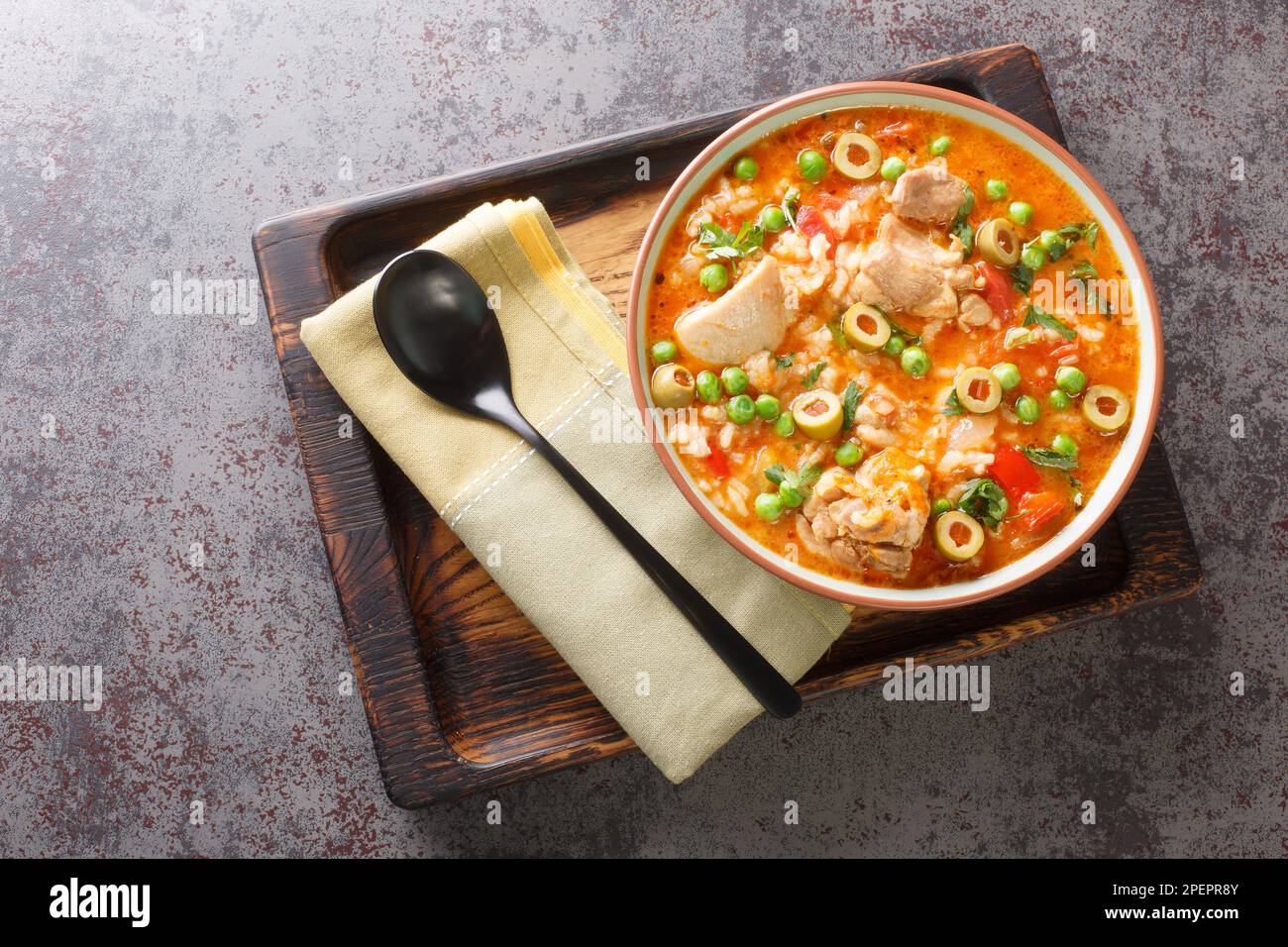 Asopao de pollo is a Caribbean dish that consists of sofrito, rice, tomato  paste, and bite sized pieces of chicken closeup on the bowl on the table. H  Stock Photo - Alamy