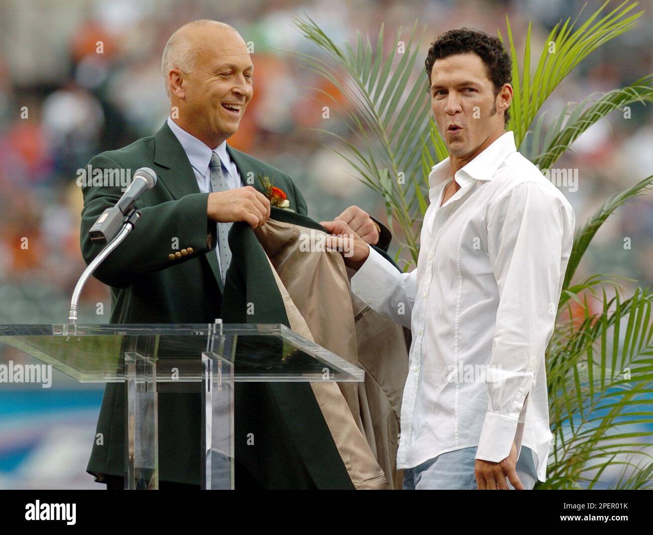 Former Baltimore Orioles Cal Ripken Jr., left, and Brady Anderson, right,  have a laugh as Anderson is inducted into the Orioles' Hall of Fame during  a ceremony before a game against the