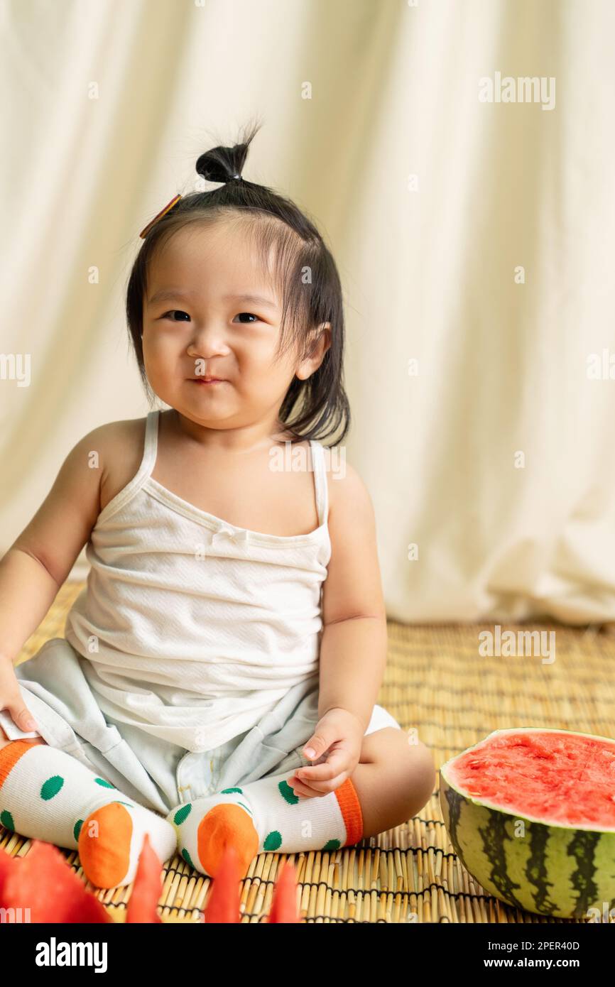 The lovely baby girls eat watermelon Stock Photo