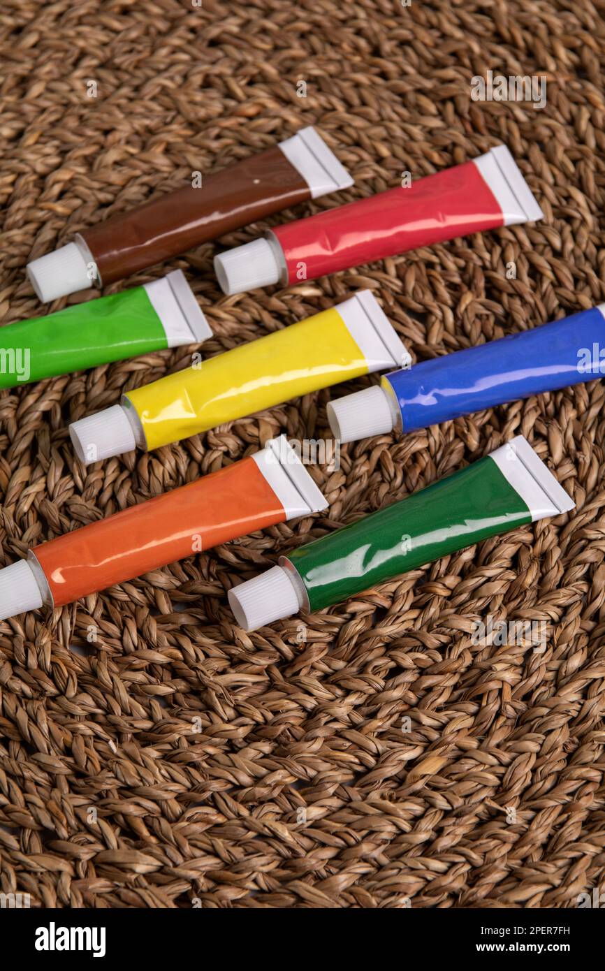 photo of lots of paint in tubes on a wicker napkin Stock Photo