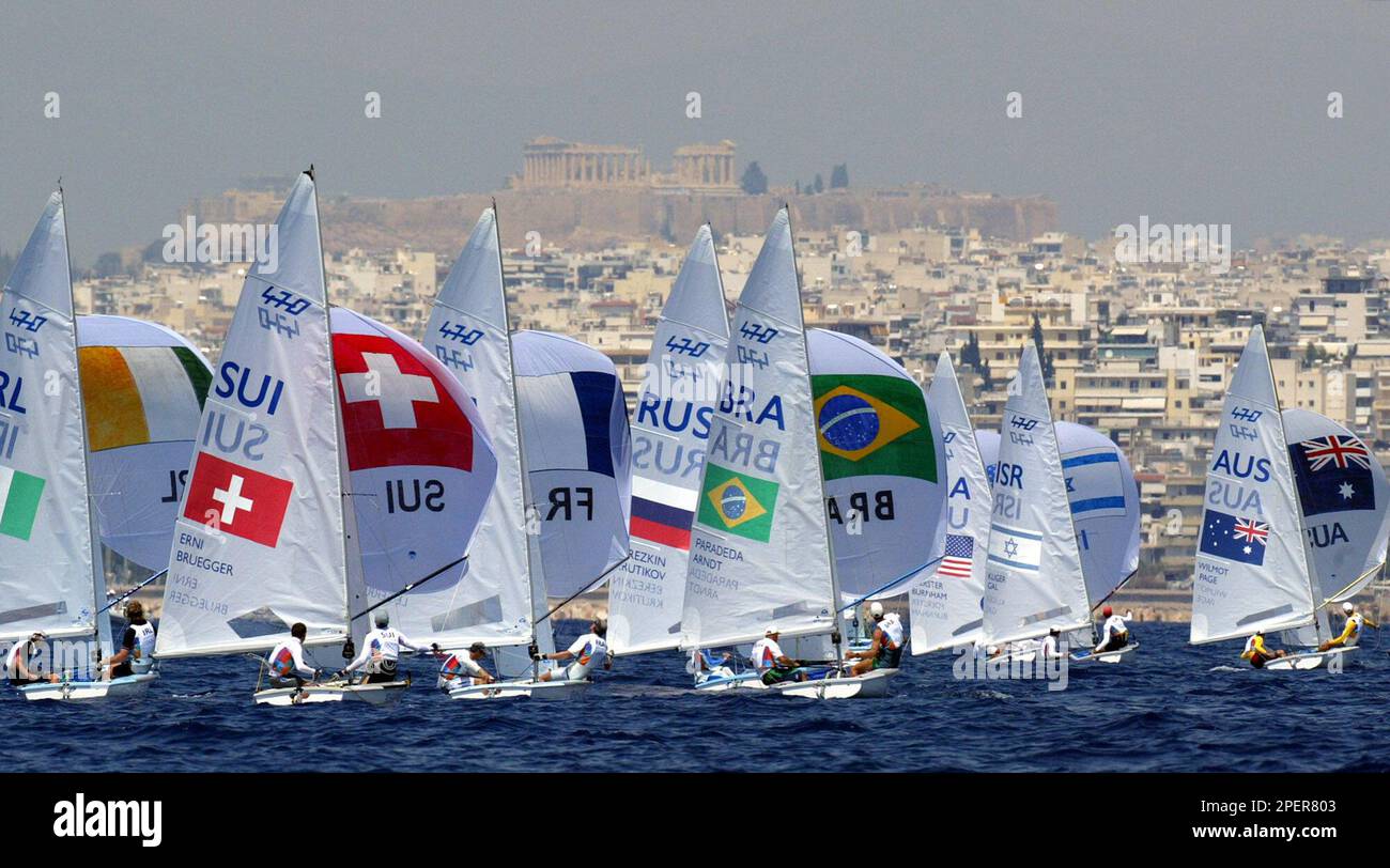 Men's doublehanded 470 dinghies sail in front of the Acropolis during