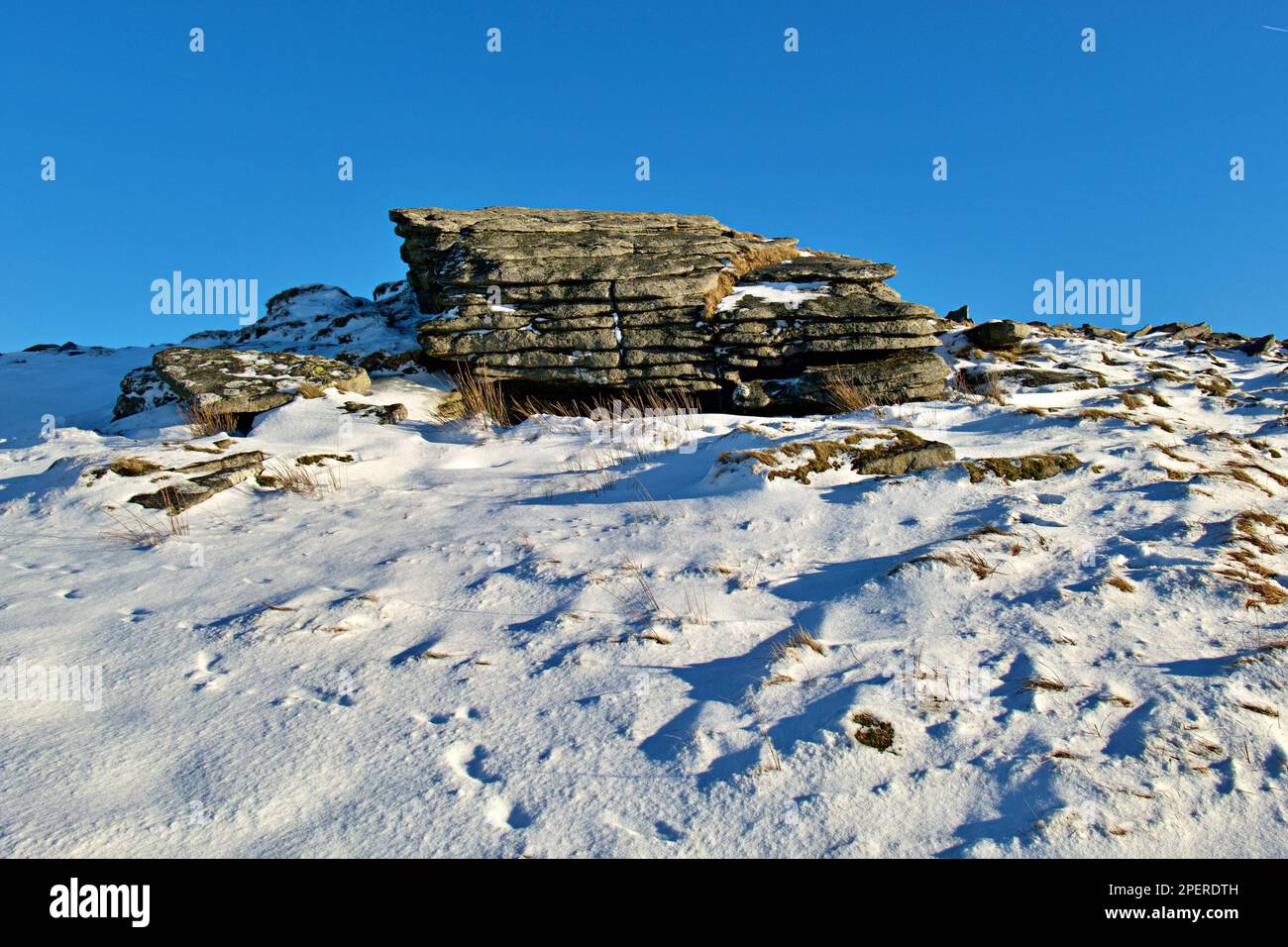 A large rock formation standing on the Yes Tor peak with an idyllic winter landscape in background Stock Photo