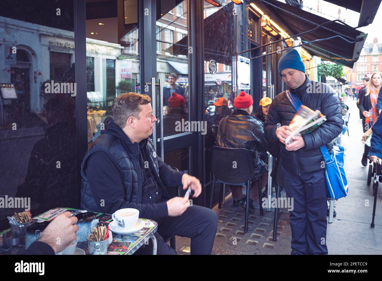Thomas Henry Skinner the English businessman and television personality talking to a homeless man, in Soho, London 16 02 2023 Stock Photo