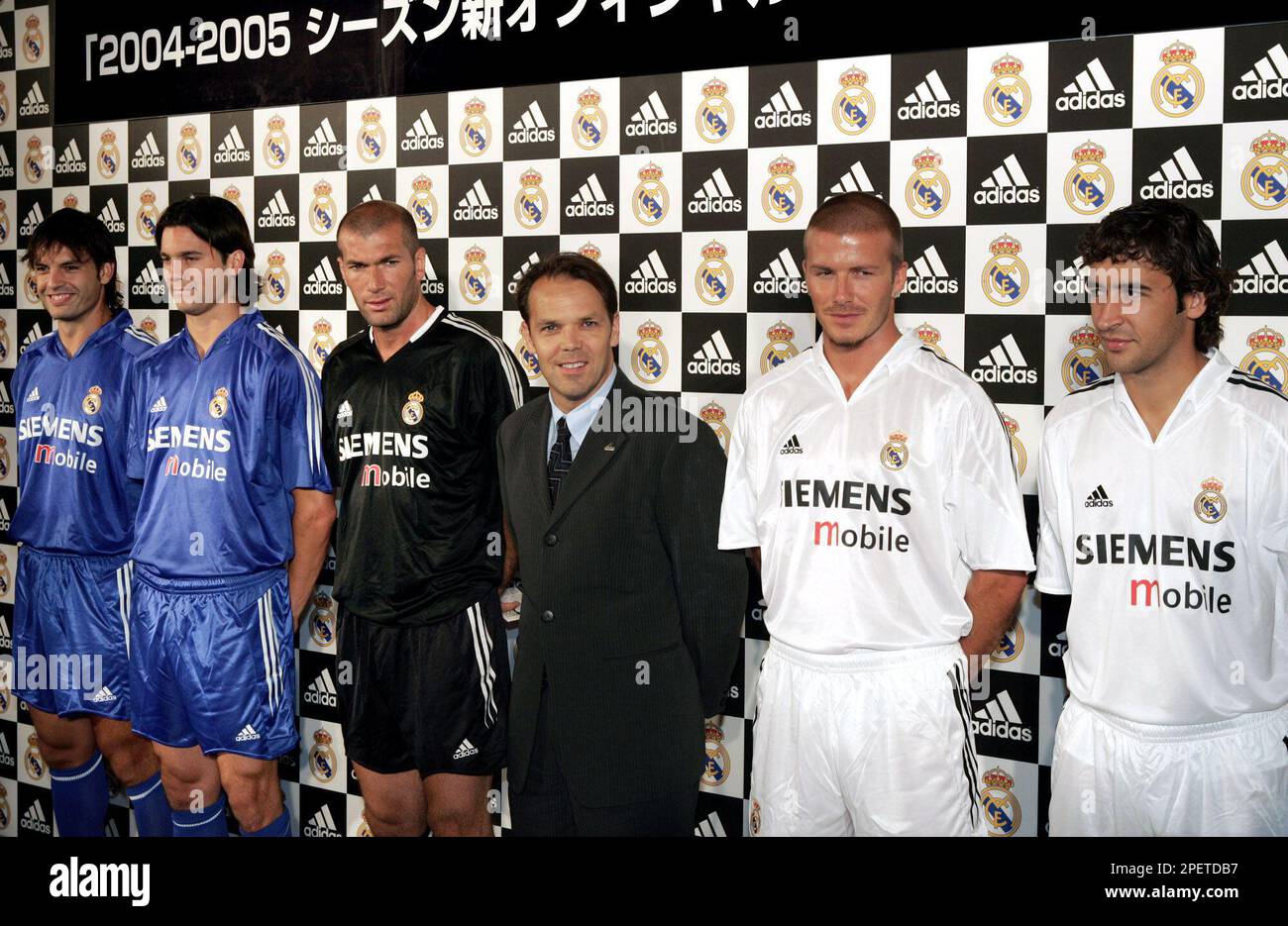Real Madrid' players wearing the Spanish giants team's new official jerseys for the 2004-2005 regular season line up with the uniform maker adidas Japan K.K. President Robert Langstaff, third from right, during a media unveiling in Tokyo Wednesday, July 28, 2004. Real Madrid, currently in Japan on a weeklong preseason tour, will play in the new jerseys in friendly matches against J-League teams JEF United Ichihara on July 29 and Tokyo Verdy 1969 on Aug. 1. Players from left are: Fernando Morientes, Santiago Solari, both in the away jerseys, Zinedine Zidane in the 3rd jersey, Langstaff, David B Stock Photo