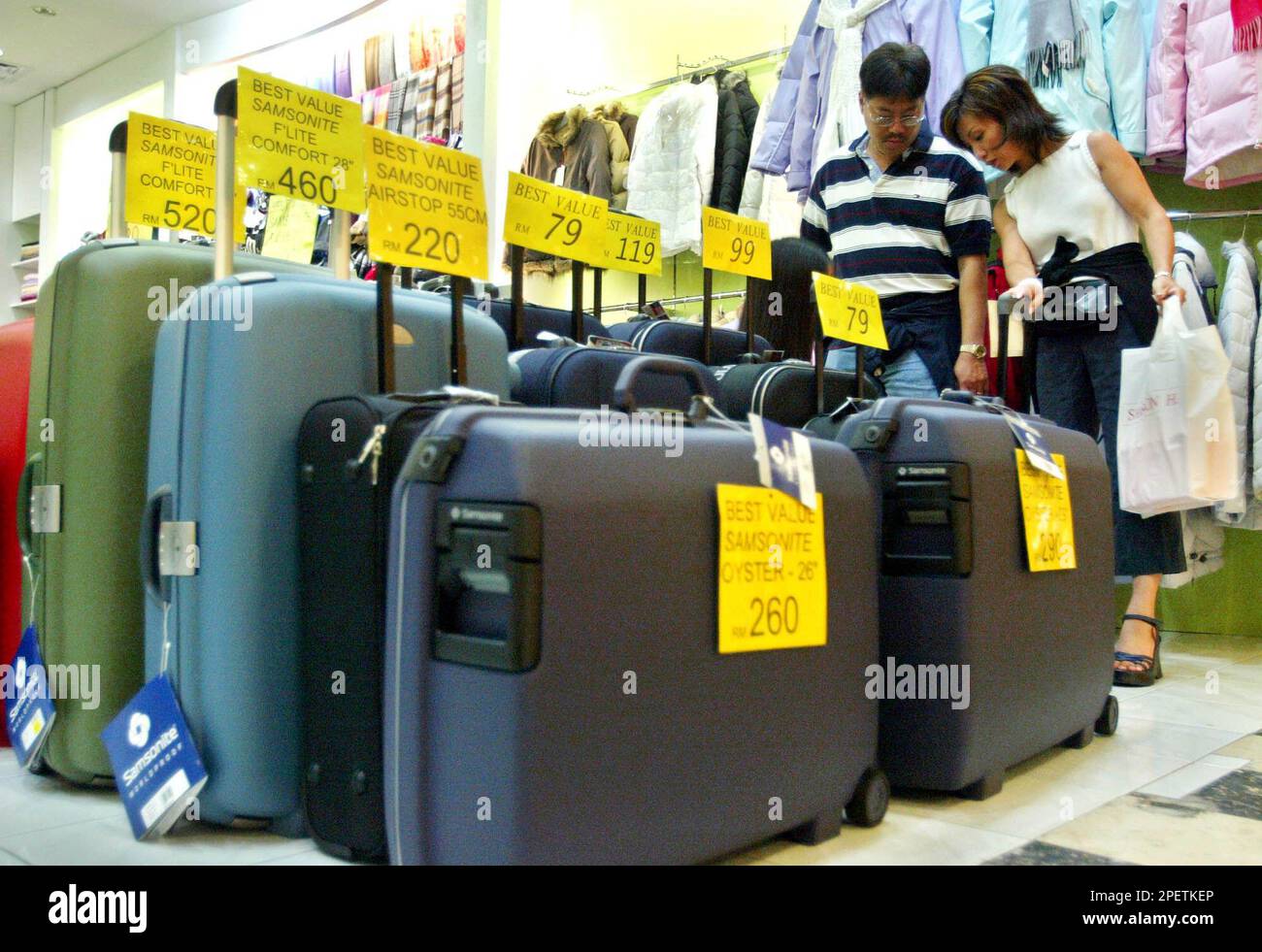 A couple shops at a boutique selling luggages and winter clothes inside