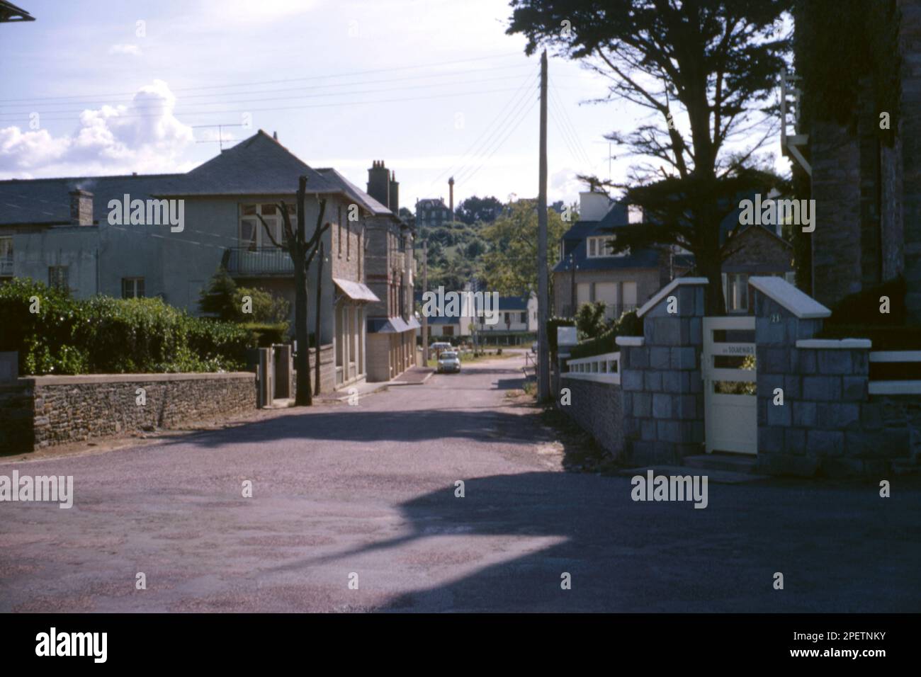 View of a road junction and traditional French houses and gardens in St