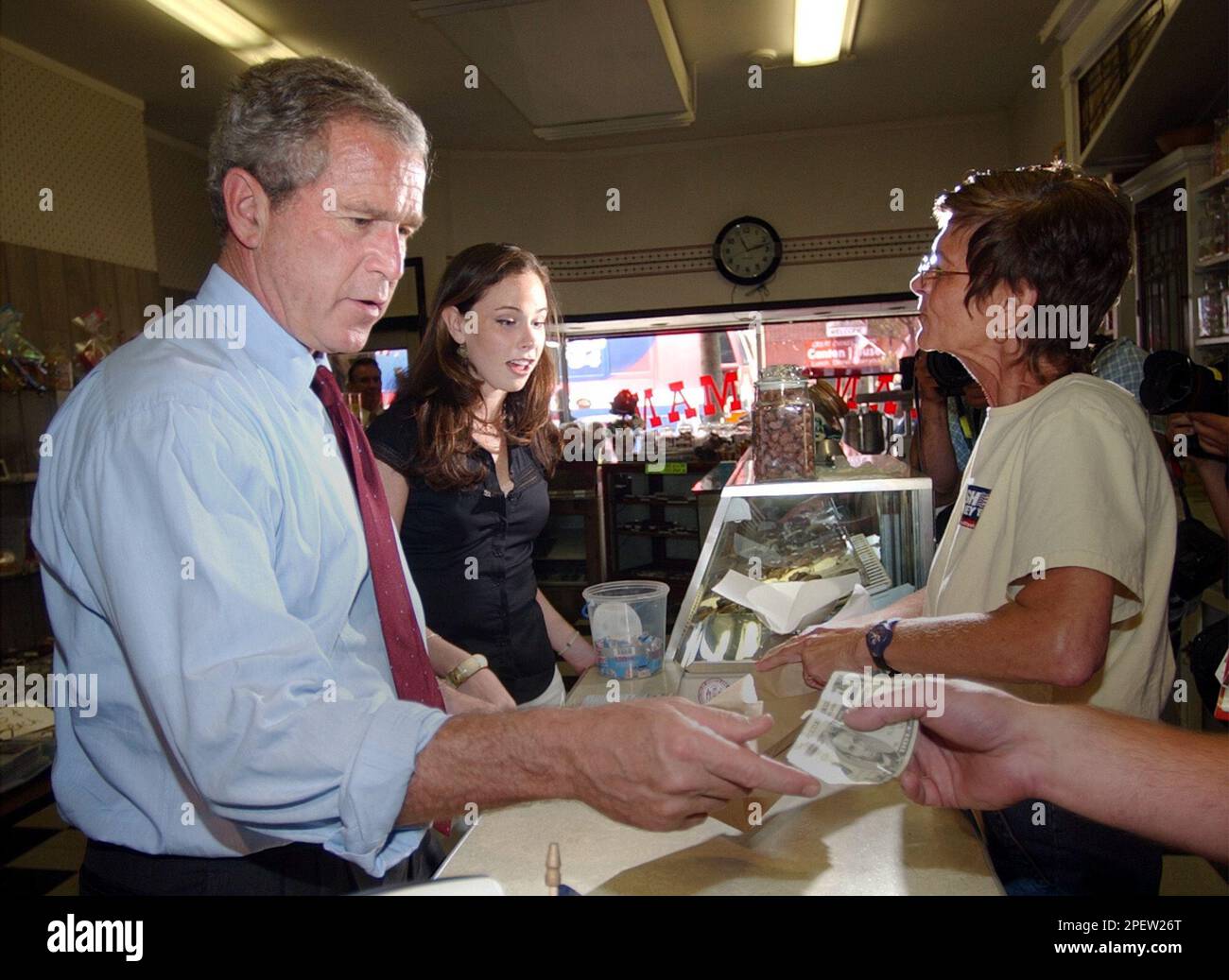 President Bush pays for candy he purchased with his daughter Barbara at