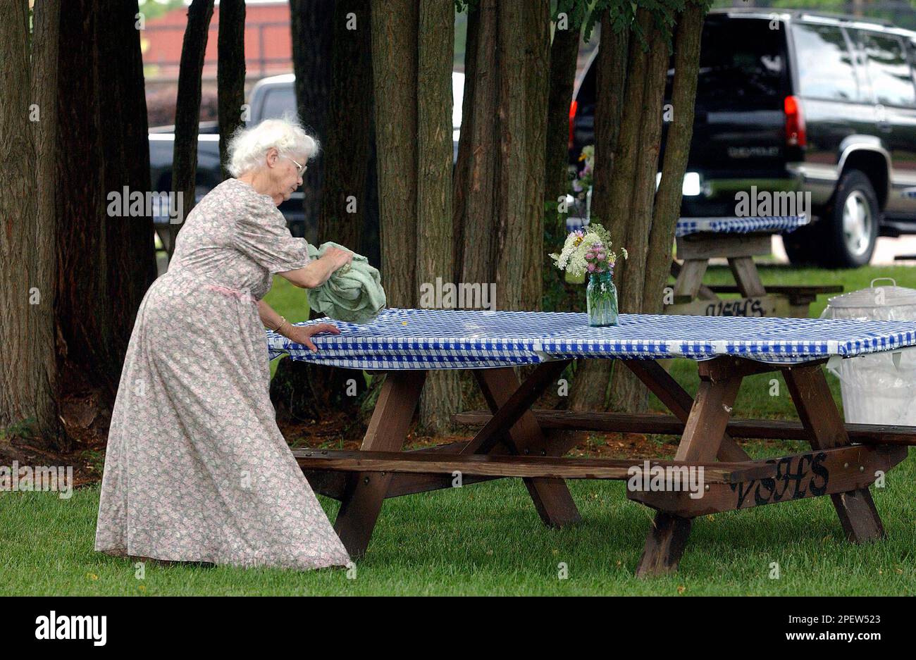 Virginia Stangle of Vincennes, Ind., wipes the rain off the tables for