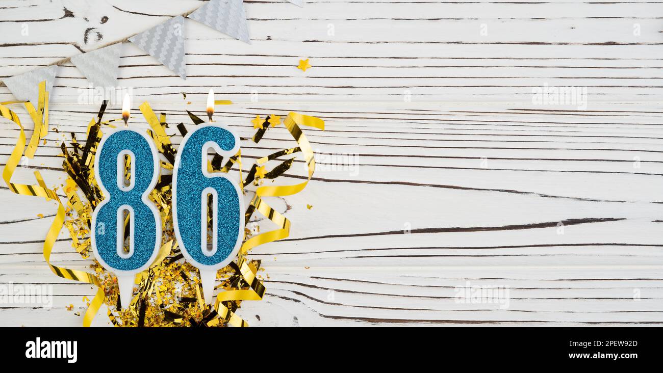 Number 86 Blue Celebration Candle On White Wooden Background Happy