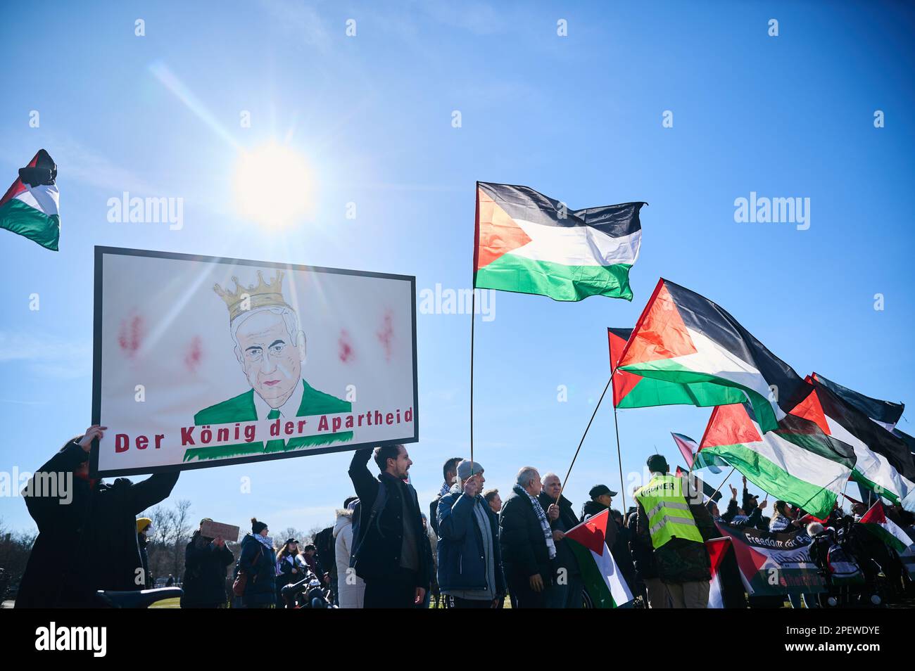 Berlin, Germany. 16th Mar, 2023. 'The king of apartheid!' is written under a likeness of the Israeli prime minister on a placard held by demonstrators in front of the Reichstag building on the occasion of netanyahu's visit. Credit: Annette Riedl/dpa/Alamy Live News Stock Photo