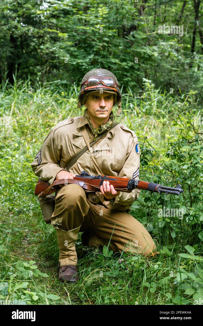 Porabka, Poland – July18, 2020 : Historical reeneactor dressed as  american  Infantry Soldier during  World War II  patrol the forest. Stock Photo