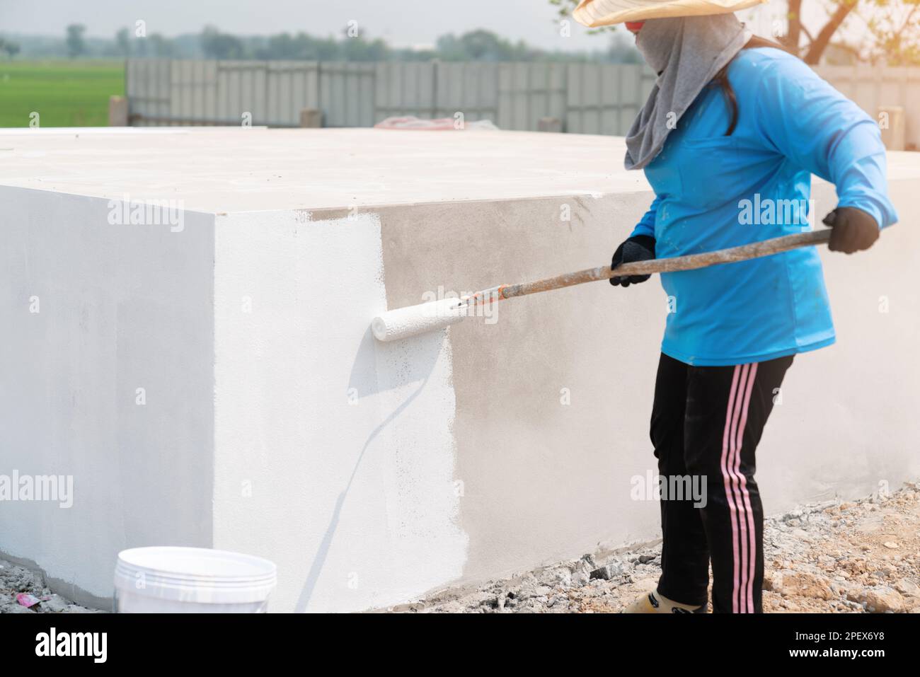 Workers are painting plasterboard walls in building construction Stock