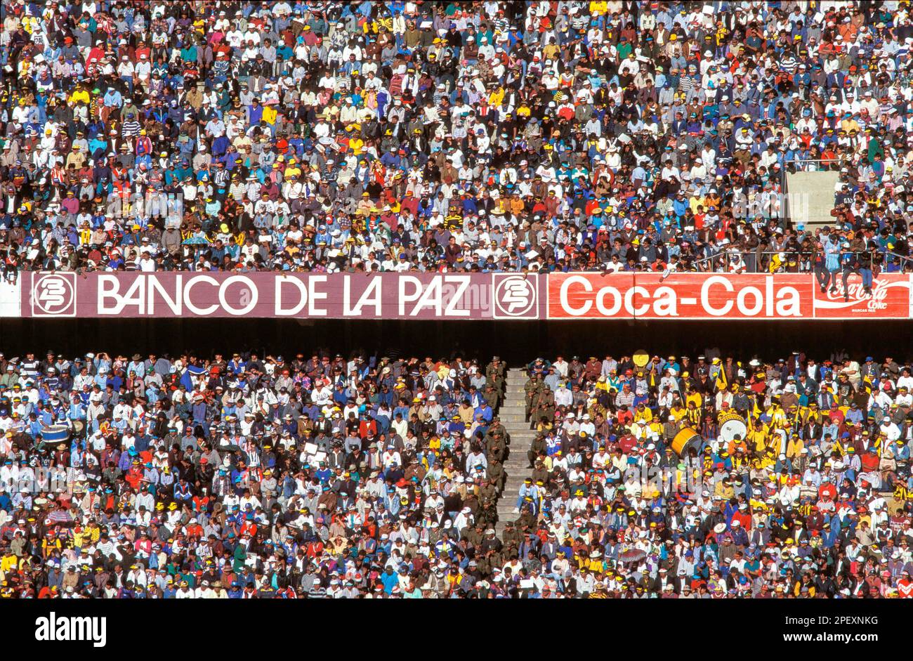 Bolivia, La Paz, El Alto Supporters at a soccer game with advertising of a national bank and a multinational.. Stock Photo