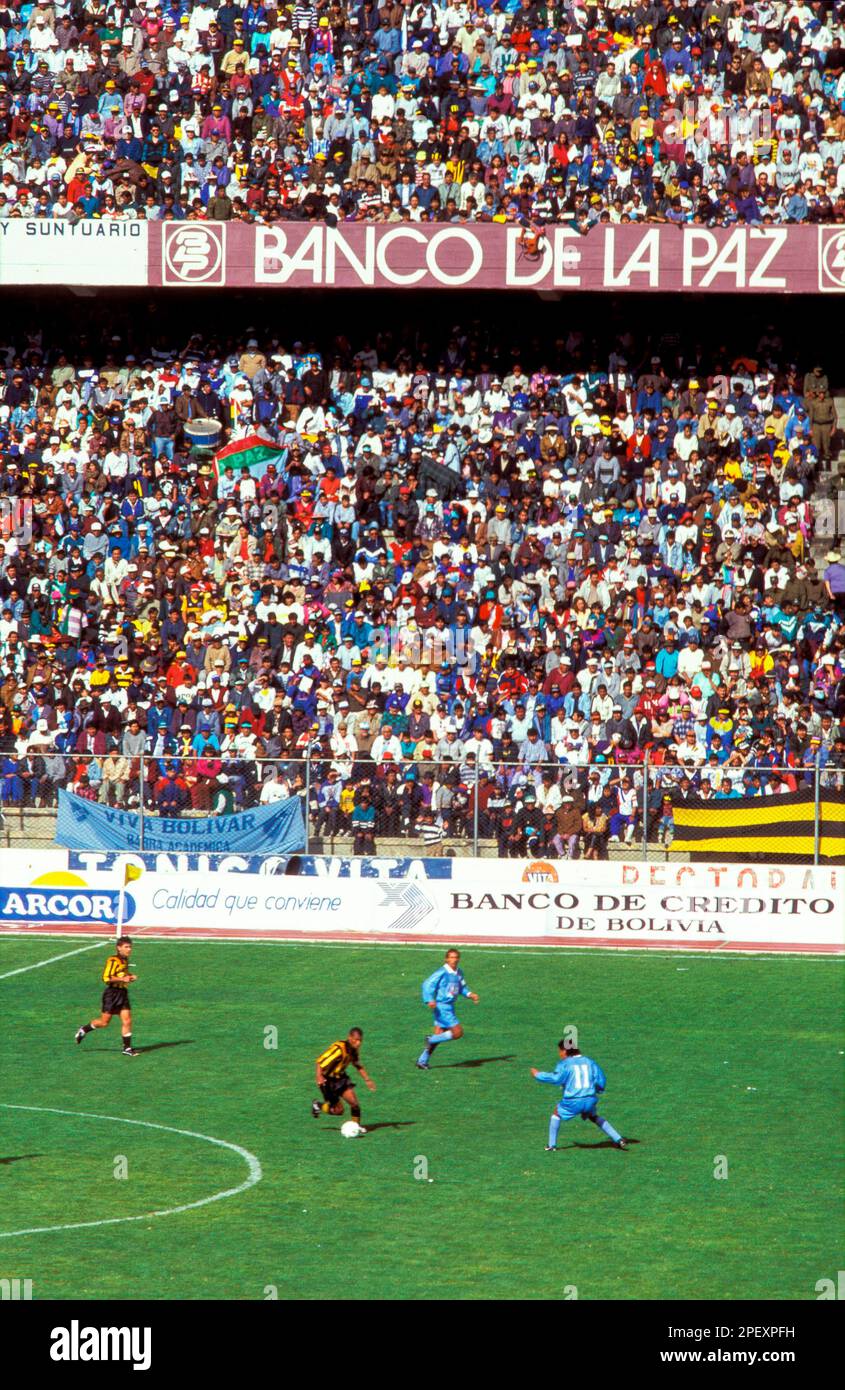 Bolivia, La Paz, El Alto Supporters at a soccer game with advertising of a national bank and a multinational.. Stock Photo