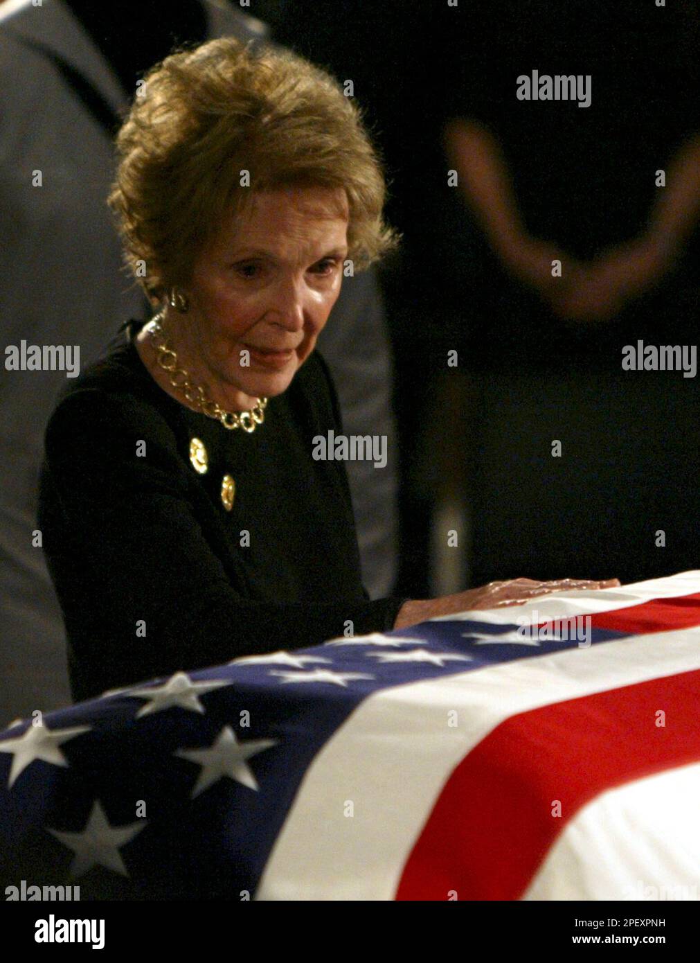 Former first lady Nancy Reagan pauses at the casket of her husband ...