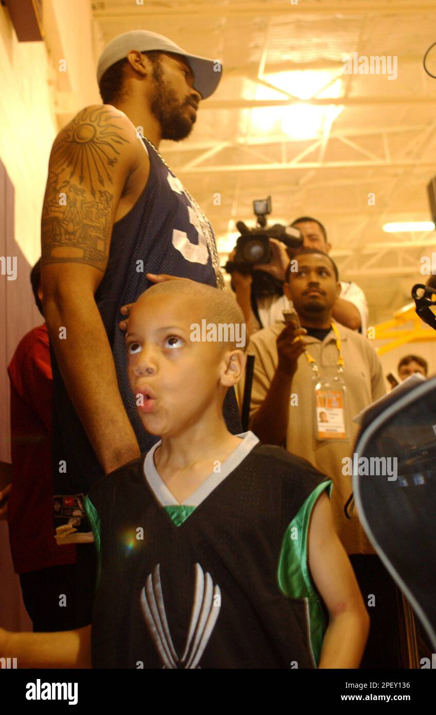 Detroit Pistons' Rasheed Wallace talks with reporters while his 6-year-old son, Nazir, plays before a practice Saturday, June 5, 2004, in El Segundo, Calif. The opening game of the NBA Finals betwen the Pistons and the Los Angeles Lakers is Sunday.(AP Photo/Michael Tweed) Stock Photo