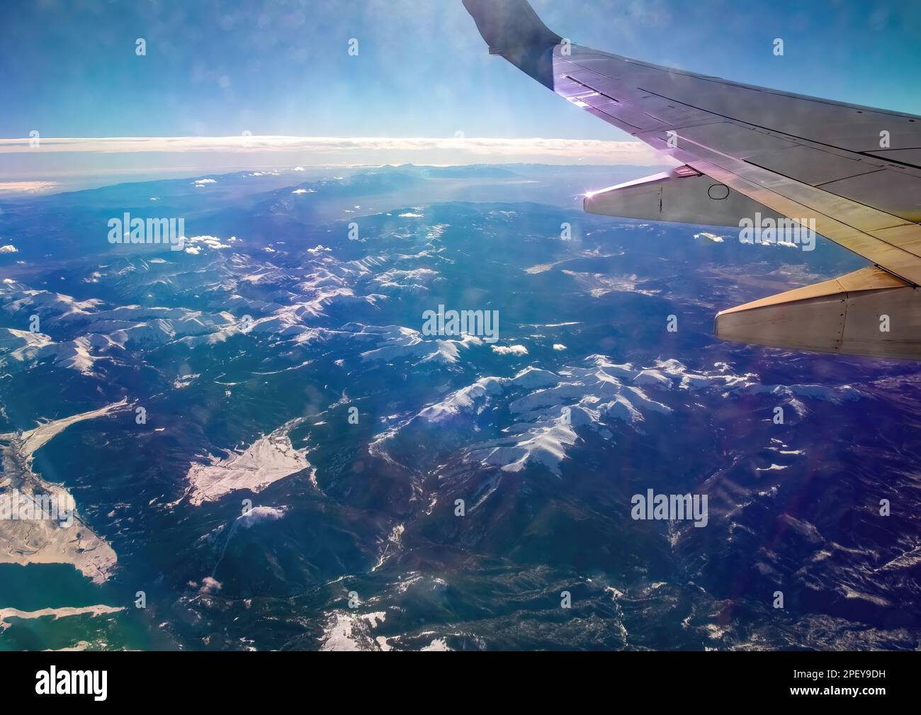 Sun County Arlines plane flight flying over the Rocky Mountains of