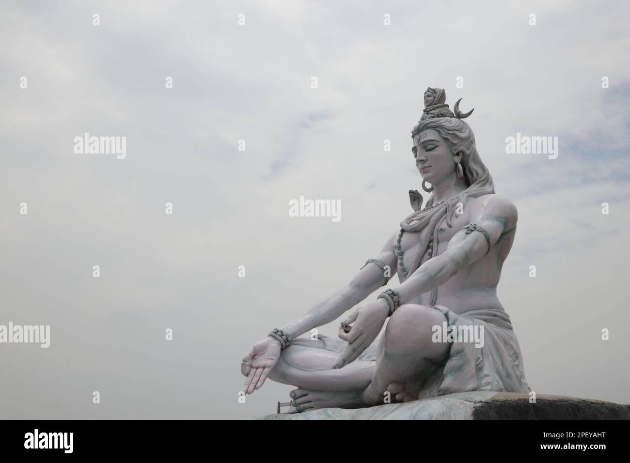 Statue of lord Shiva. Hindu idol near Ganges River water, Rishikesh, India. The first Hindu God Shiva. Sacred places for pilgrims in Rishikesh. Stock Photo