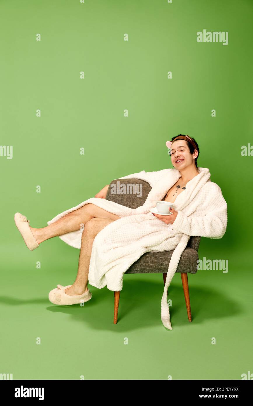 Sitting Robe Portrait of relaxing young man wearing white robe and sitting on chair ...