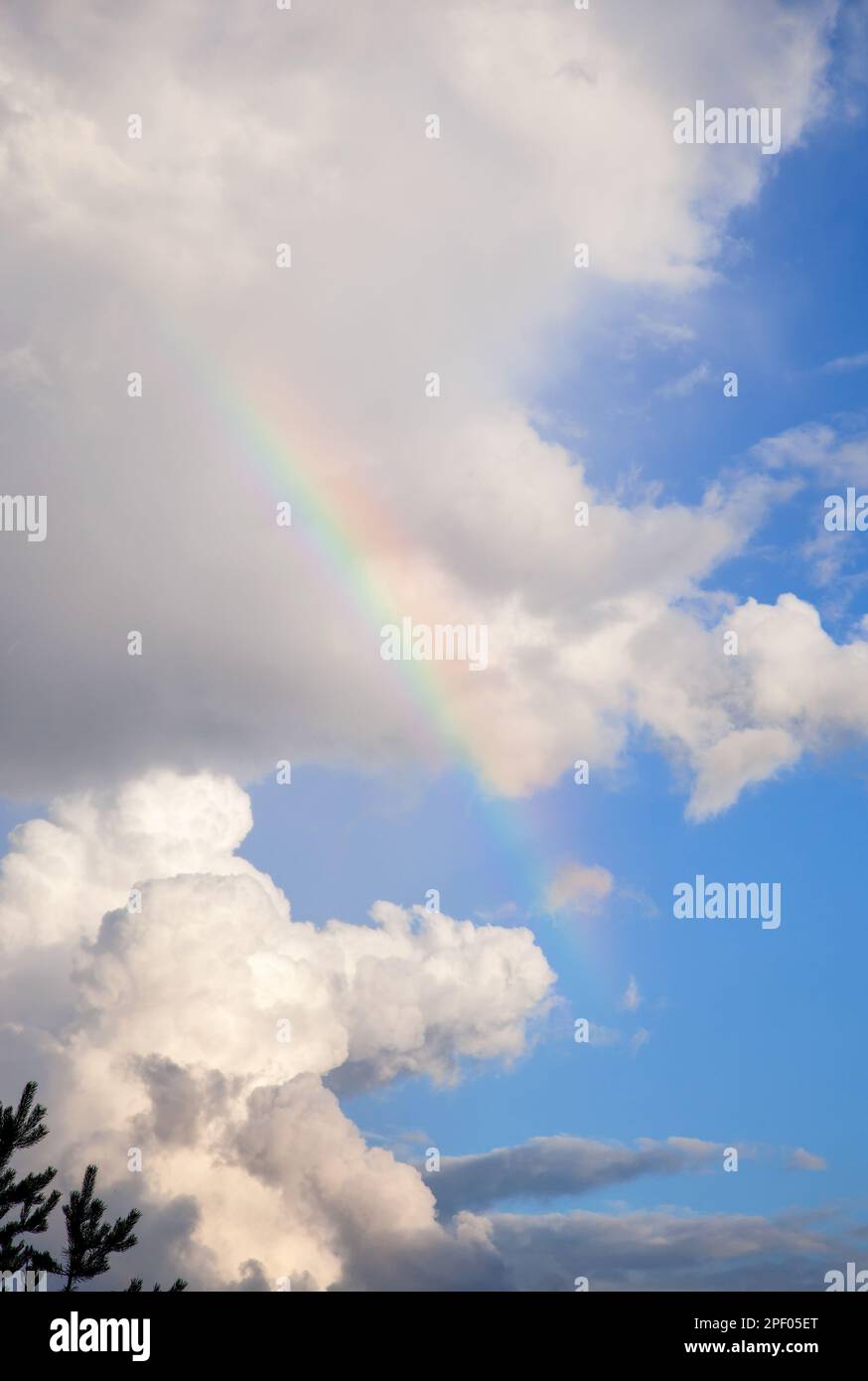 Rainbow against the a blue sky and white clouds Stock Photo - Alamy