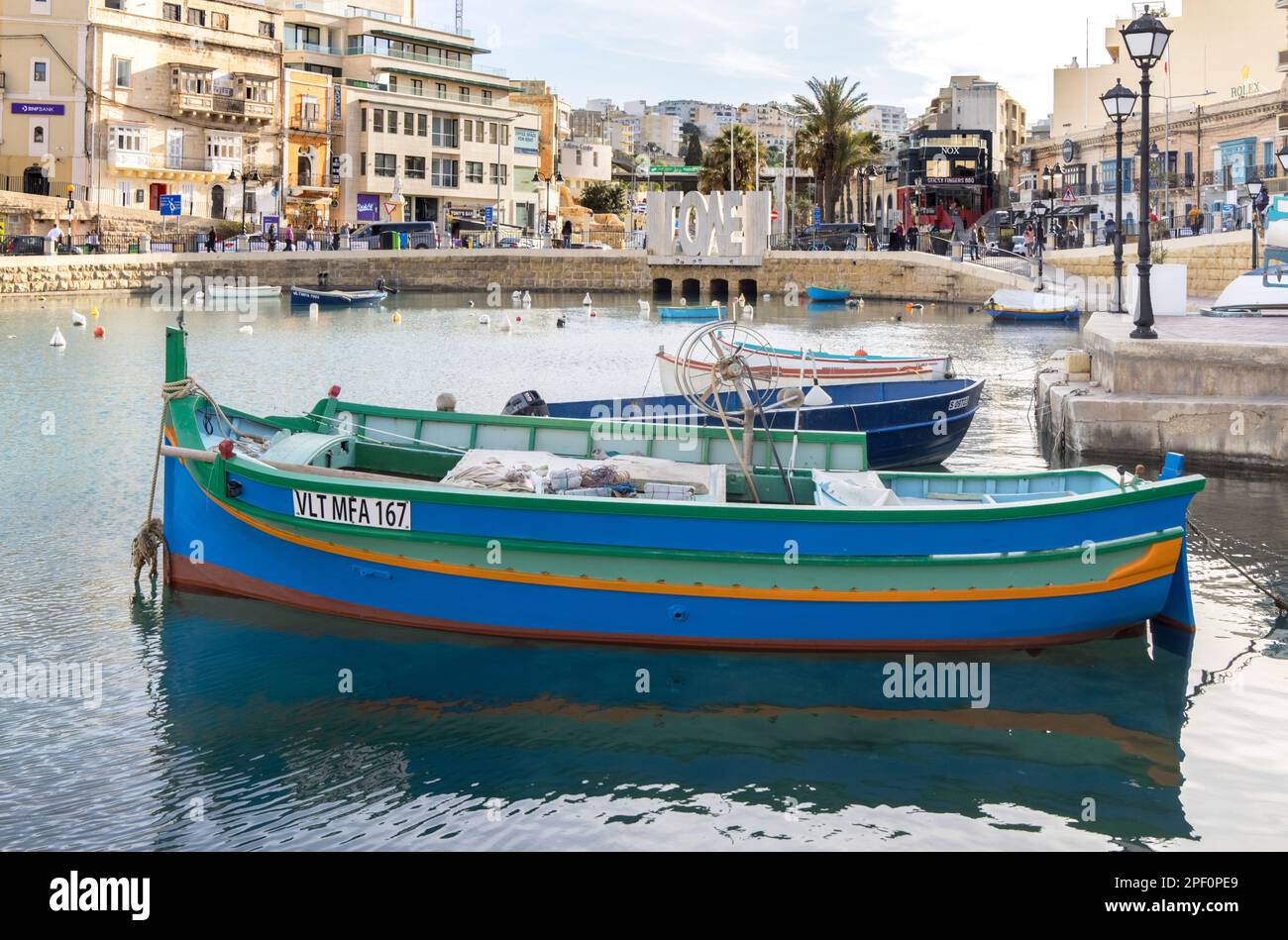 brightly coloured boats moored in spinola bay at st julians malta Stock Photo