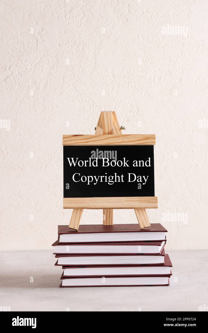 World Book and Copyright Day written on black board on stack of books on white background. book holiday, education concept Stock Photo