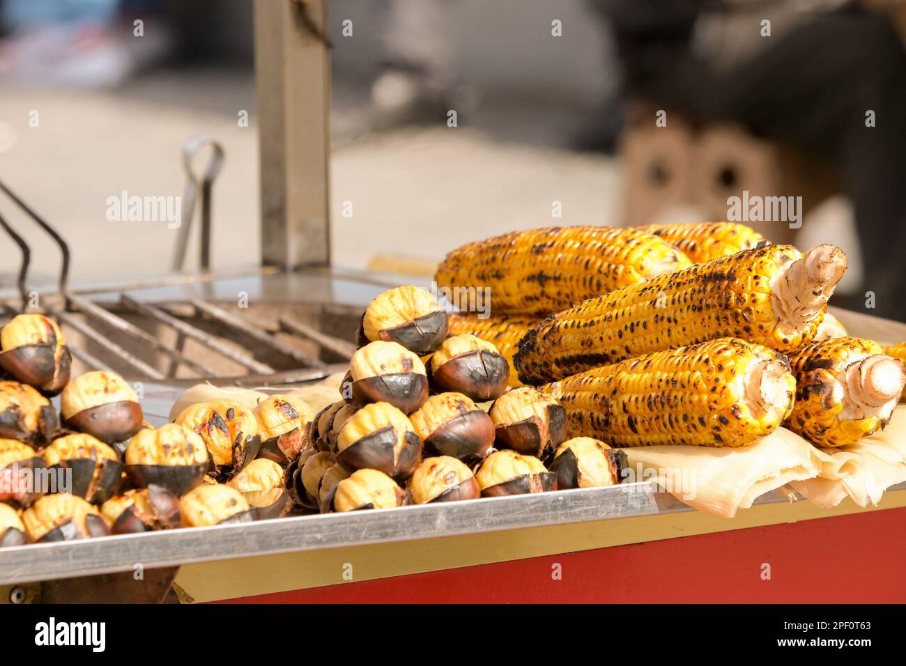 Closed roasted grilled fresh corn and chestnut at street vendors. Street food corn concept in