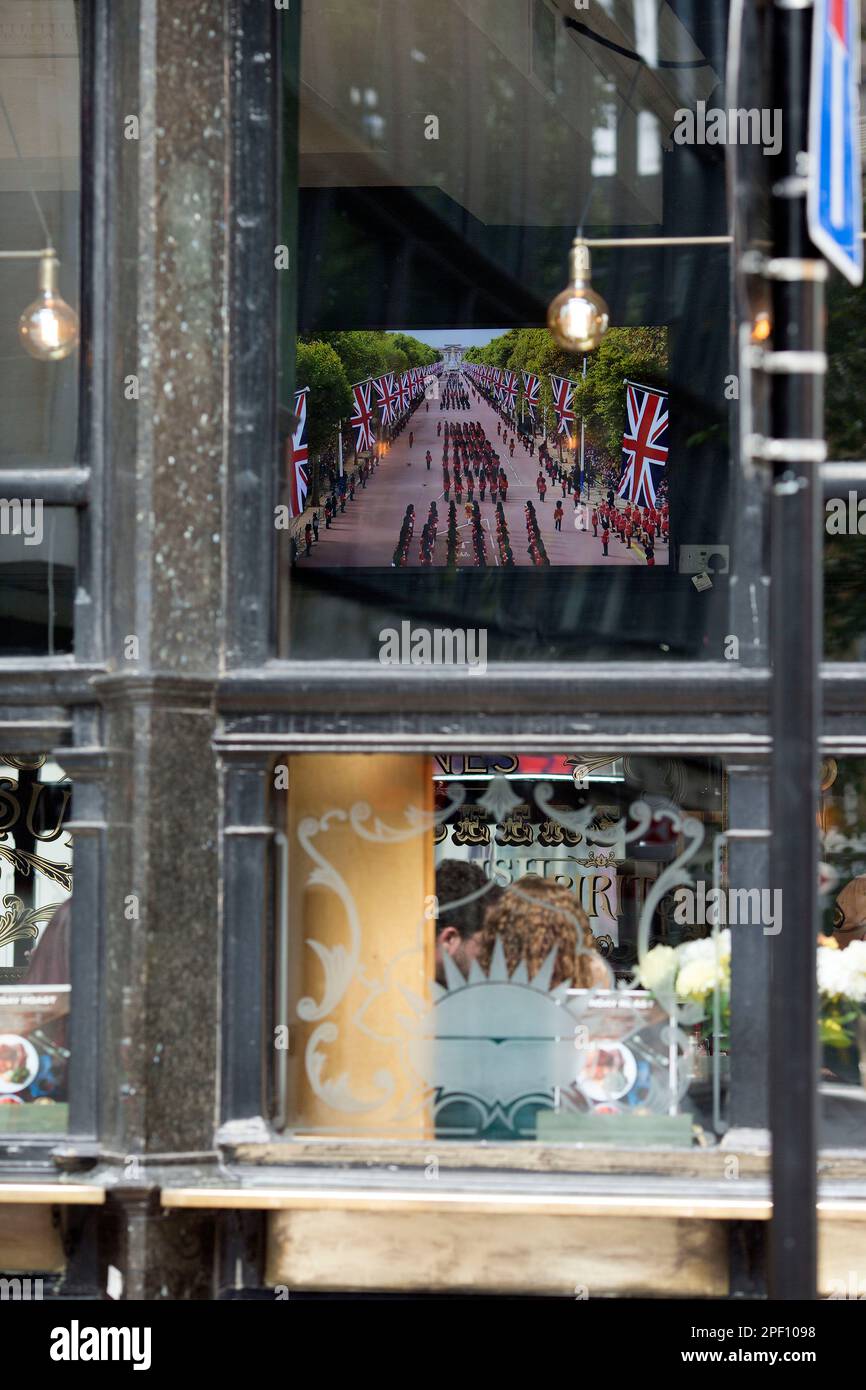 A TV screen displays the funeral day coverage of the late Queen ...