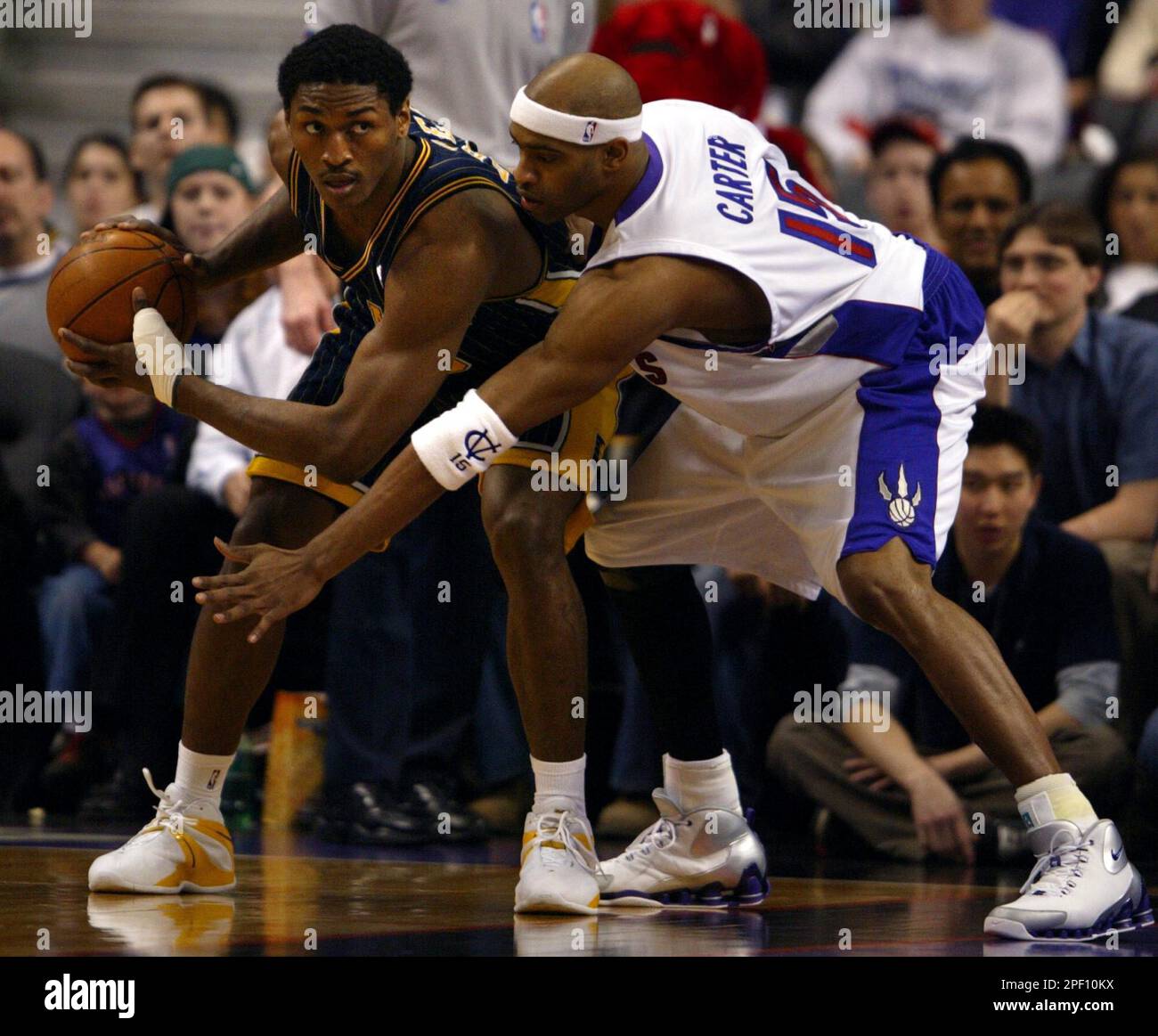 Toronto Raptors' Vince Carter tries to slow down Indiana Pacers Ron Artest during NBA action in Toronto, Wednesday April 7, 2004. (AP PHOTO/Adrian Wyld) Stock Photo