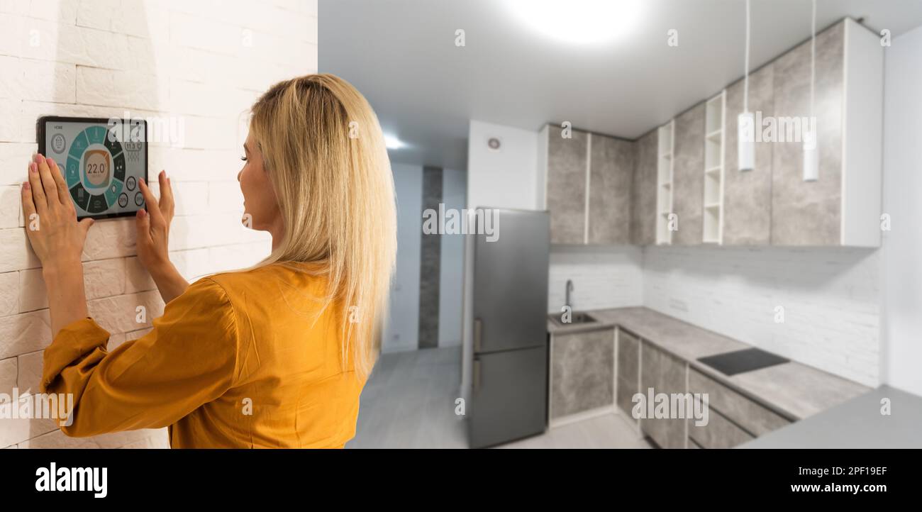 Woman using smart wall home control system Stock Photo