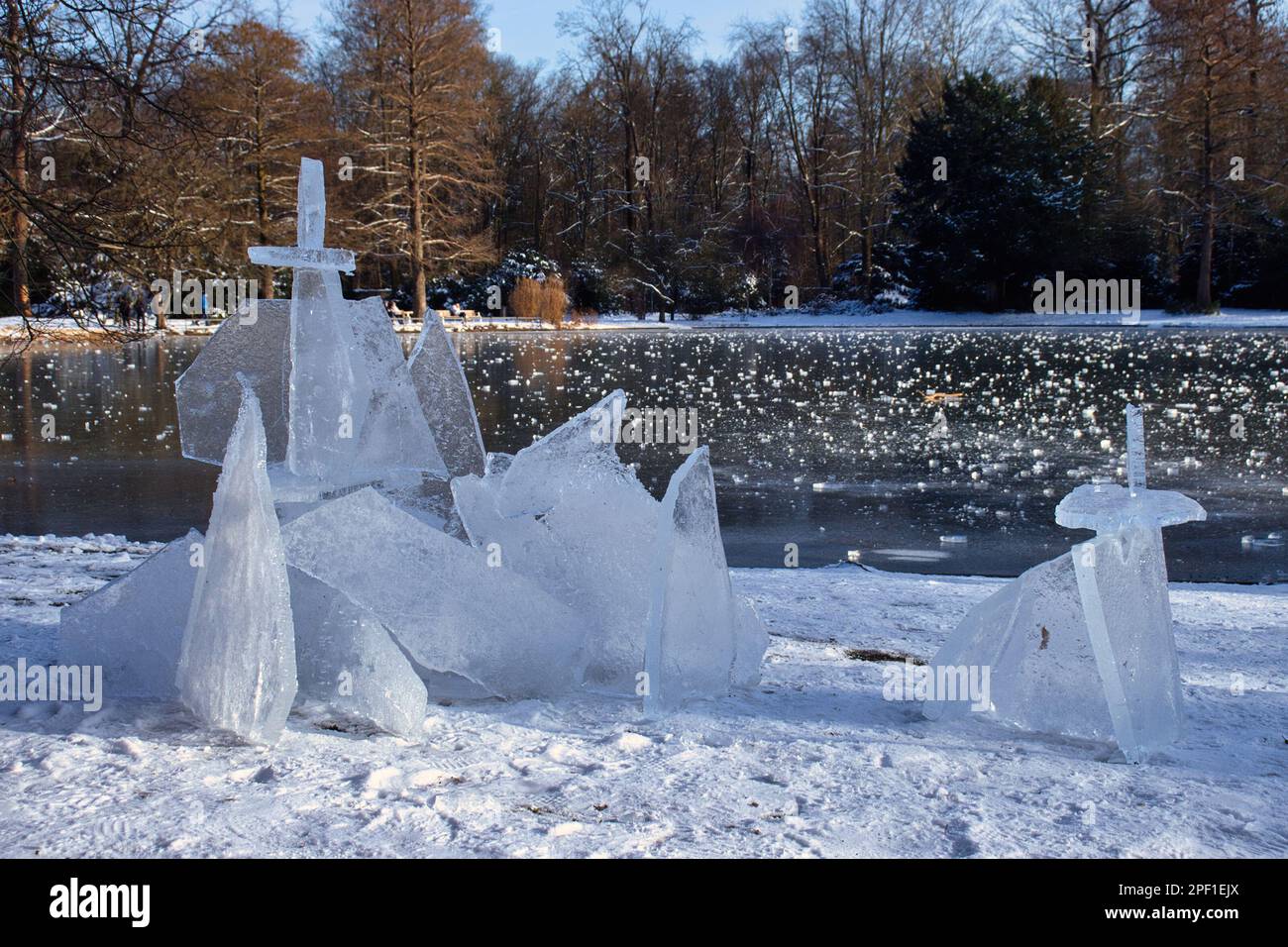 Karlsruhe, Germany - February 12, 2021: Chunks of ice piled up next to a small pond at the Karlsruhe Palace gardens on a winter day in Germany. Stock Photo