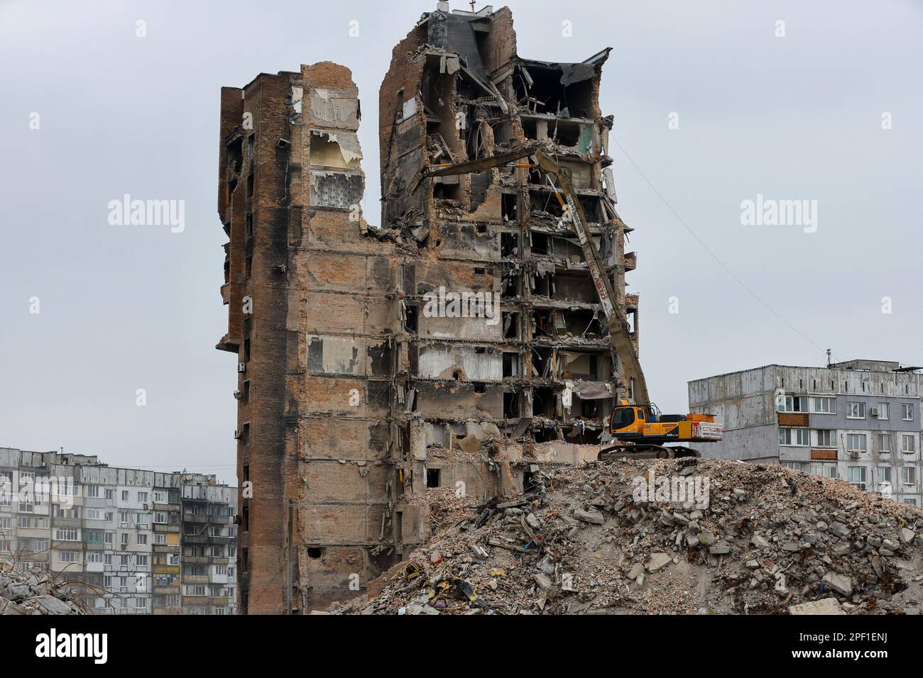 An xcavator demolishes a multi-storey apartment block, which was destroyed in the course of Russia-Ukraine conflict, in Mariupol, Russian-controlled Ukraine, March 16, 2023. REUTERS/Alexander Ermochenko Stock Photo