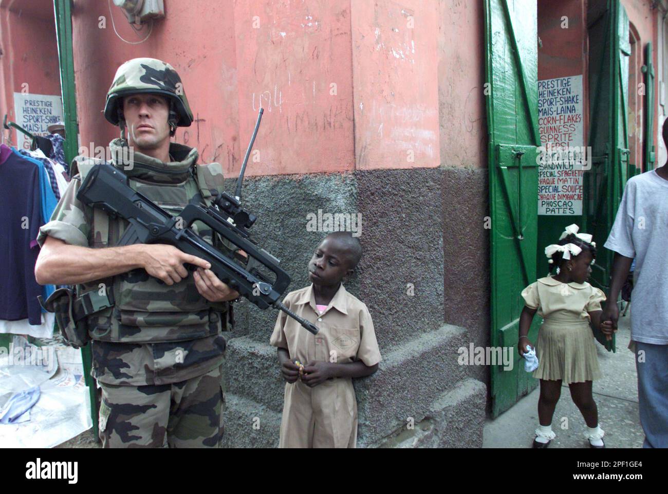 A little boy observes the gun of a French soldier patrolling the ...