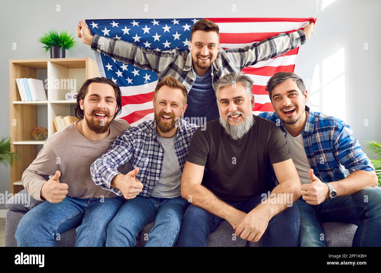 Happy American father and sons celebrating Independence Day or watching sports on TV Stock Photo