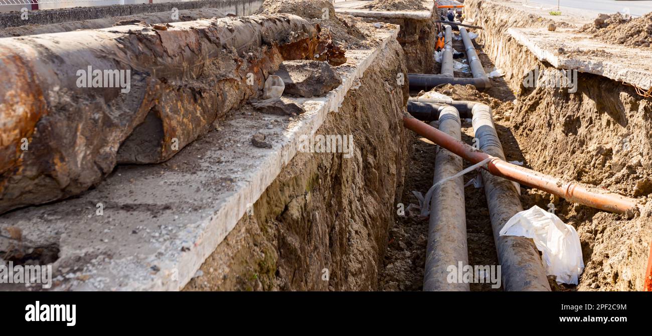 Old broken rusty rotten pipes are taken out from the trench and ...