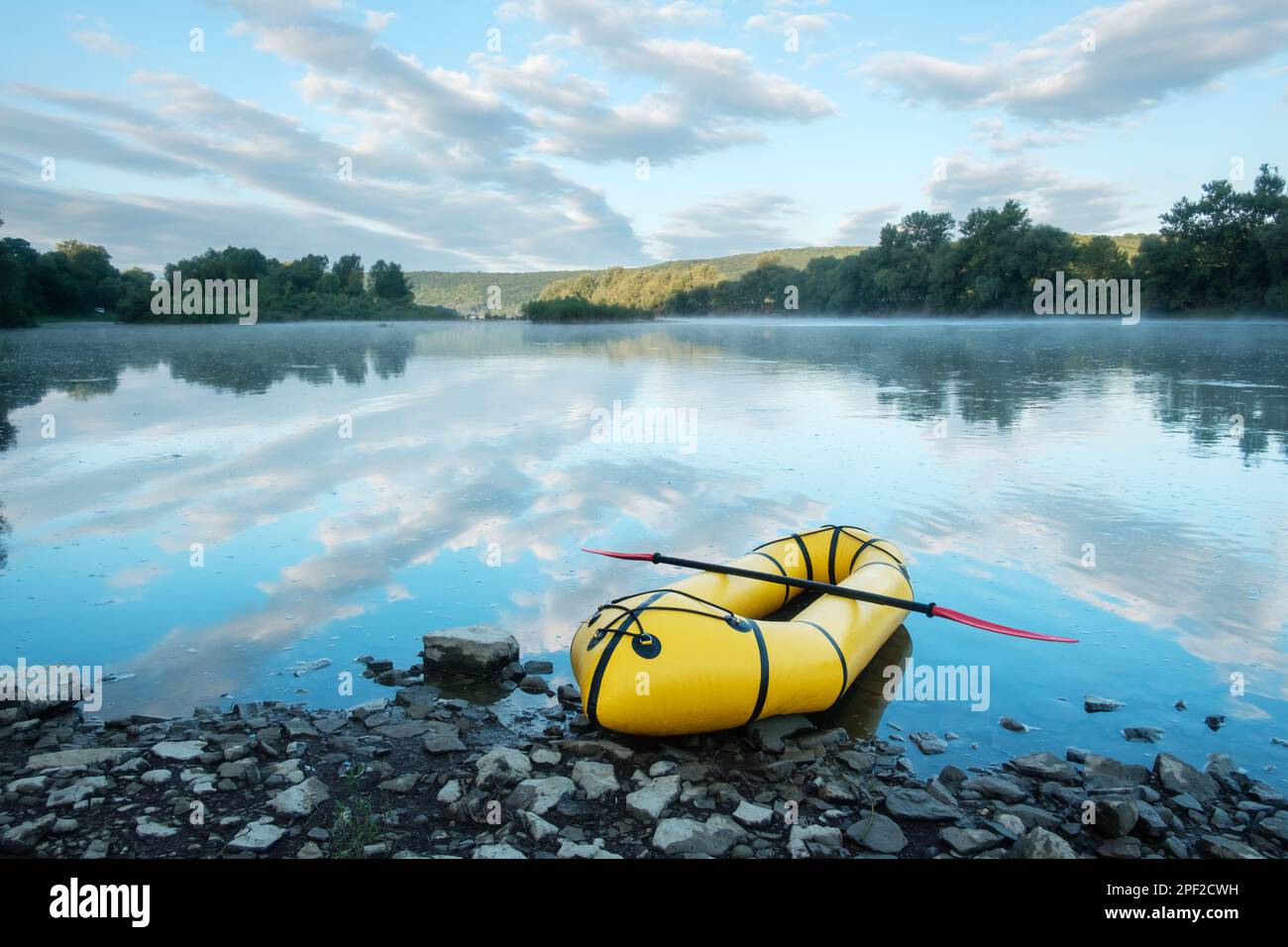 Yellow packraft boat on sunrise river Dnister in Ukraine. Packrafting concept. Active lifestile background Stock Photo