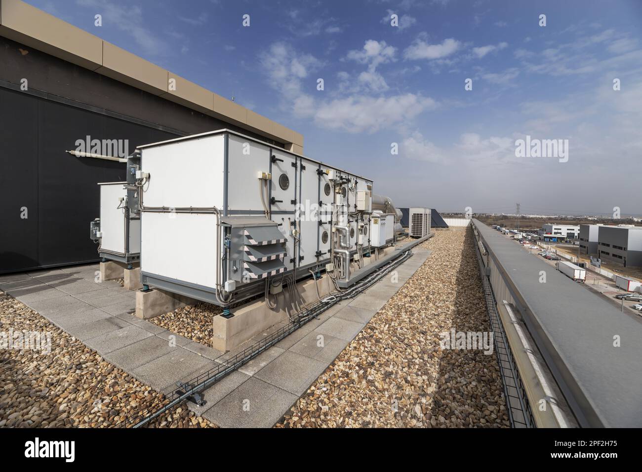 Equipment with filters and air conditioners on the roof of an industrial warehouse with floors full of gravel Stock Photo