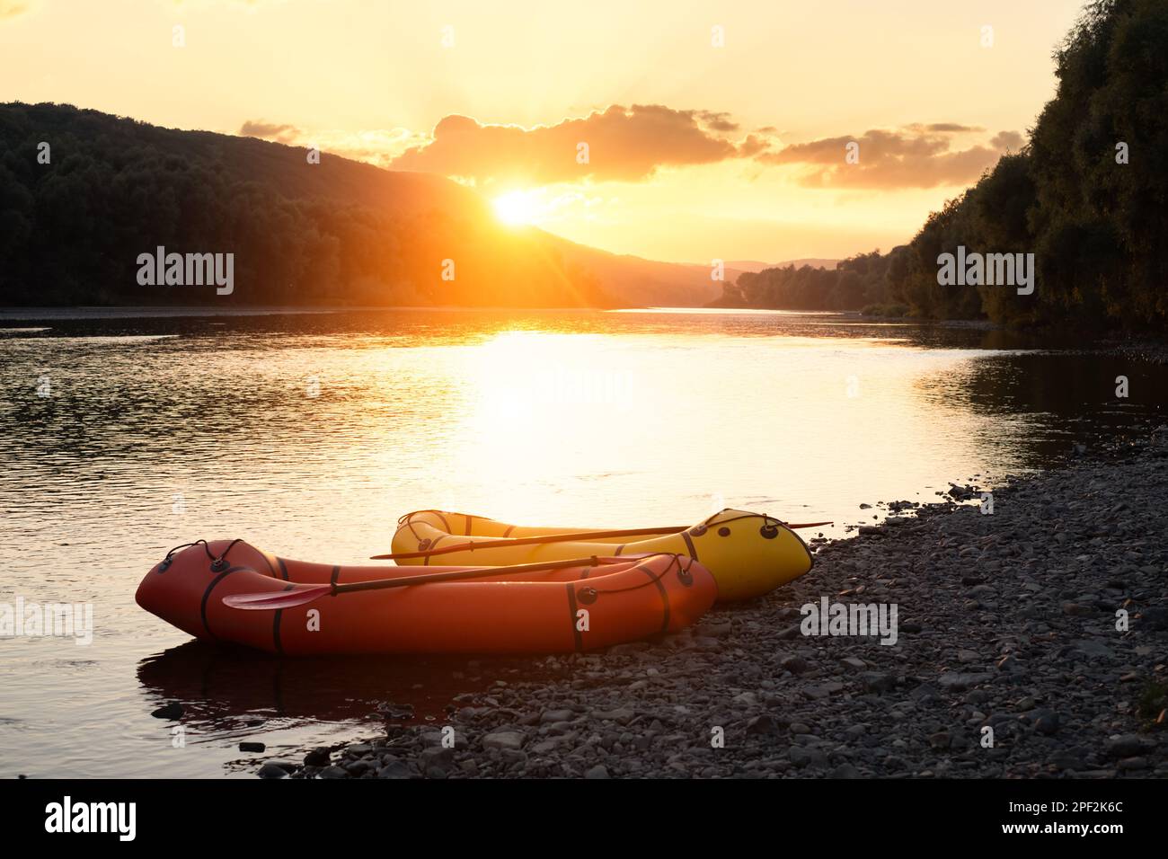 Beautiful landscape with two packrafts rubber boats on Dnister river. Incredible golden backlight from sunset sun. Packrafting and active lifestile concept Stock Photo