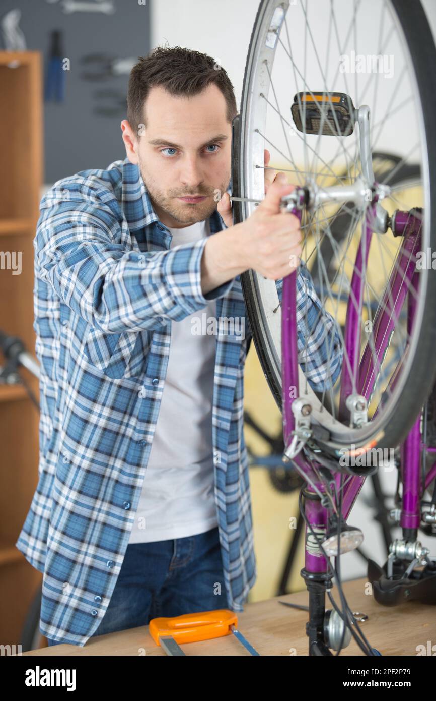 handyman fixing bike wheel in his garage Stock Photo Alamy