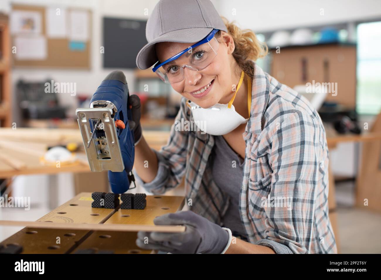 woman using electrical jigsaw wearing a dust mask Stock Photo - Alamy