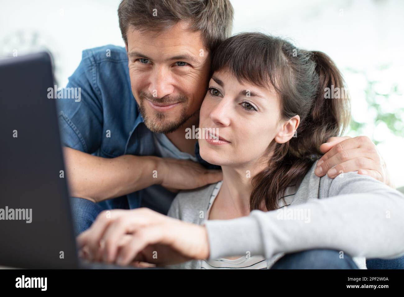couple using laptop together when sitting on the couch Stock Photo - Alamy