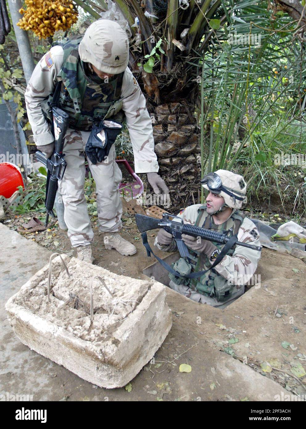 U.S. soldiers demonstrate access to the spider hole used by Saddam ...