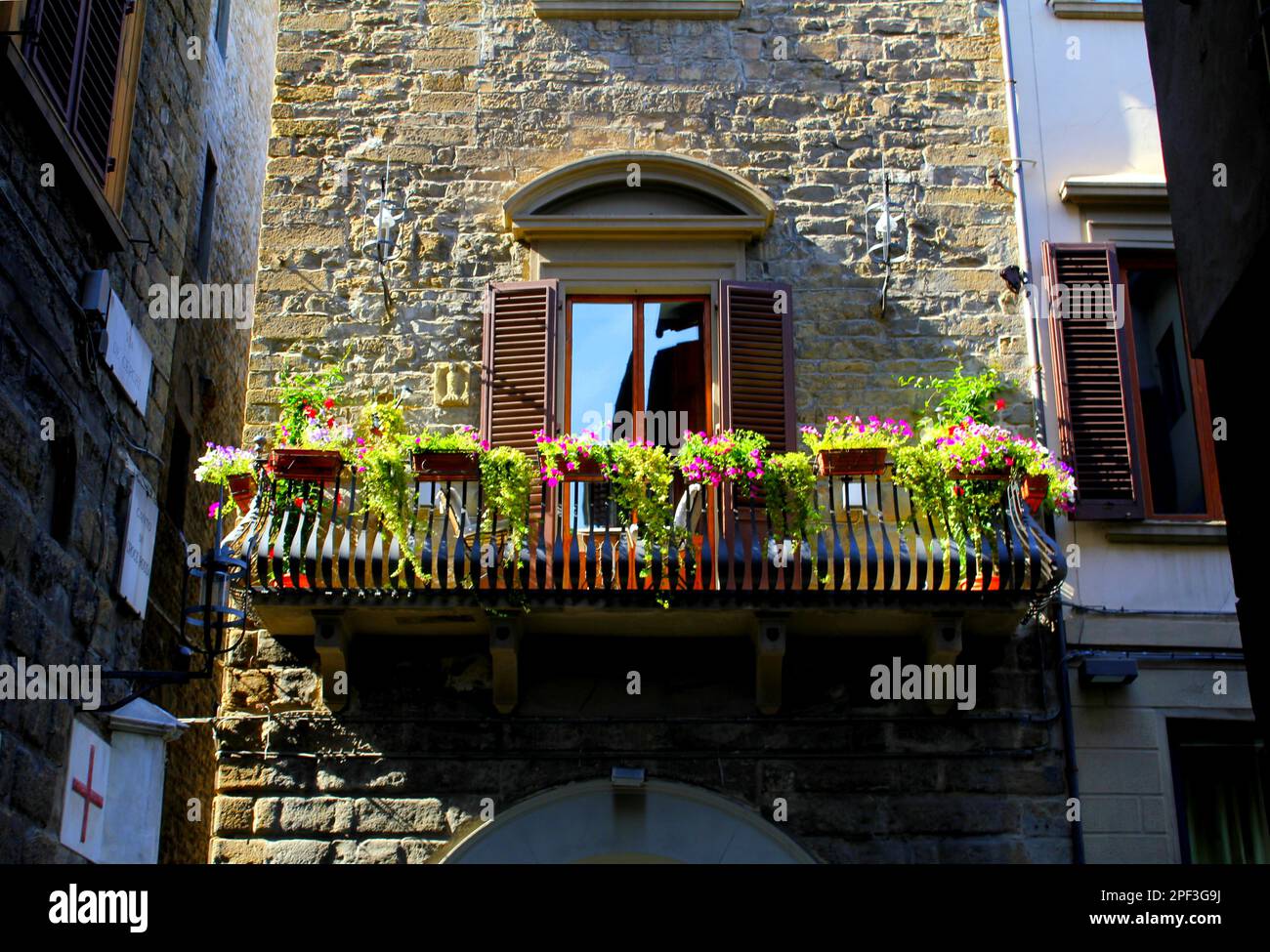 Balcony with flowers of an old stone wall Stock Photo - Alamy