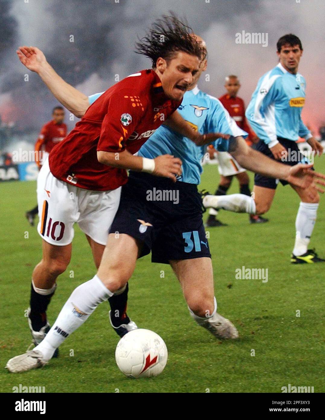 Roma's striker Francesco Totti is fouled by Lazio's Dutch defender Jaap Stam  during their Italian major league soccer match at the Olympic stadium in  Rome Sunday night, Nov.9 2003. (AP Photo/Plinio Lepri, image size:1077x1390