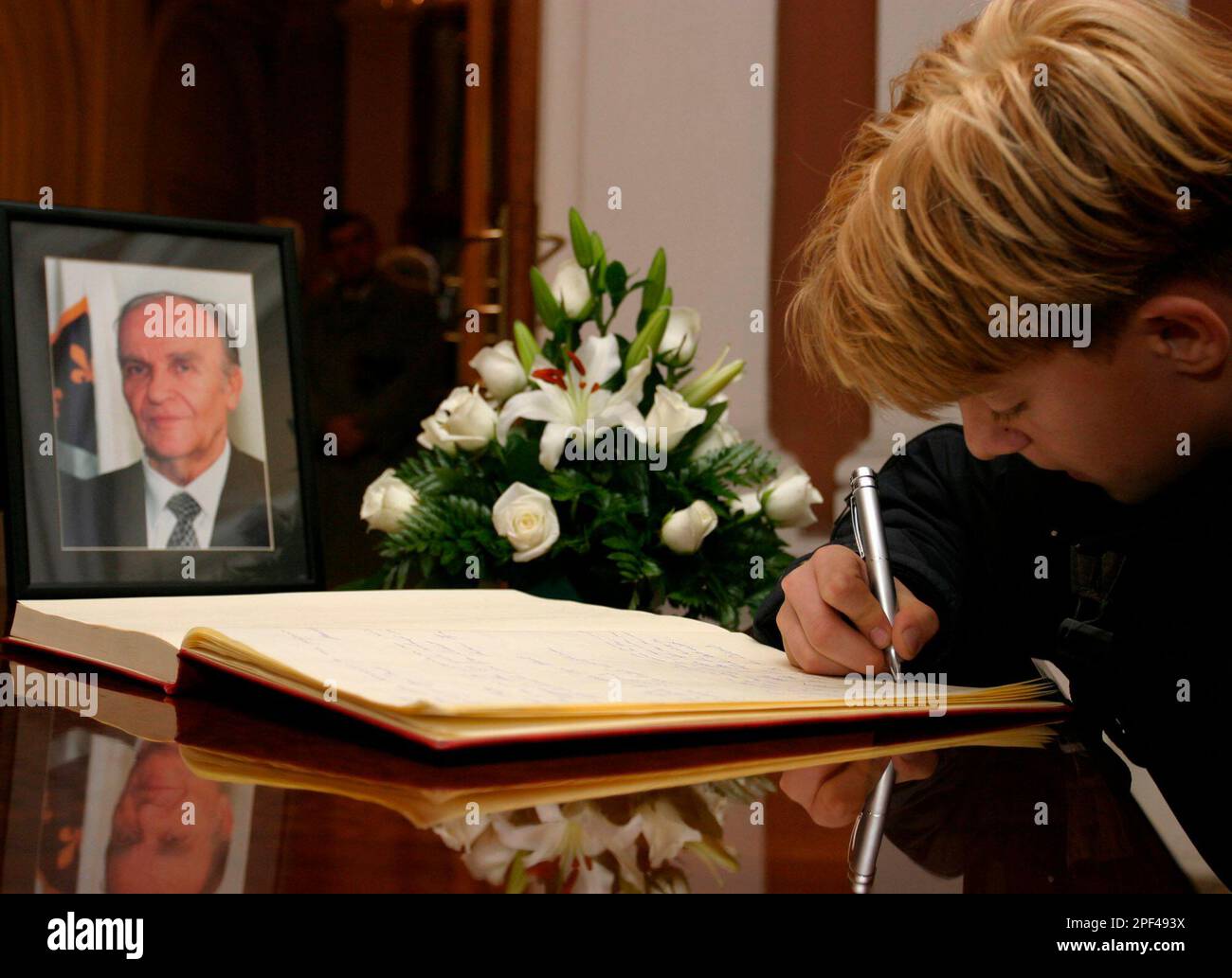 An unidentified Bosnian Muslim boy signs a condolence book in memory of